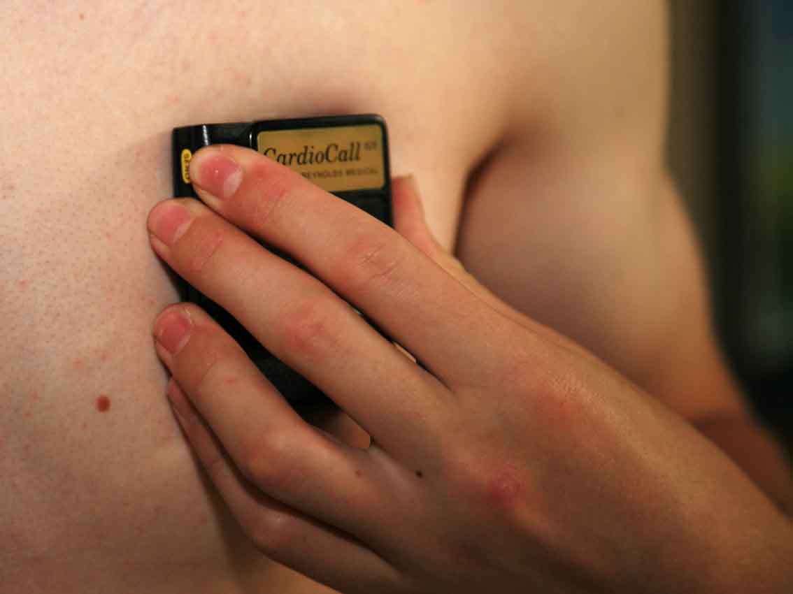 Cardiomemo device pressed against the skin of the chest to record.